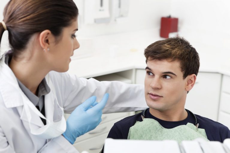 Beratungsgespraech zwischen jungem Patienten und Zahnaerztin