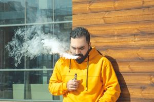 Mann dampft eine E-Zigarette